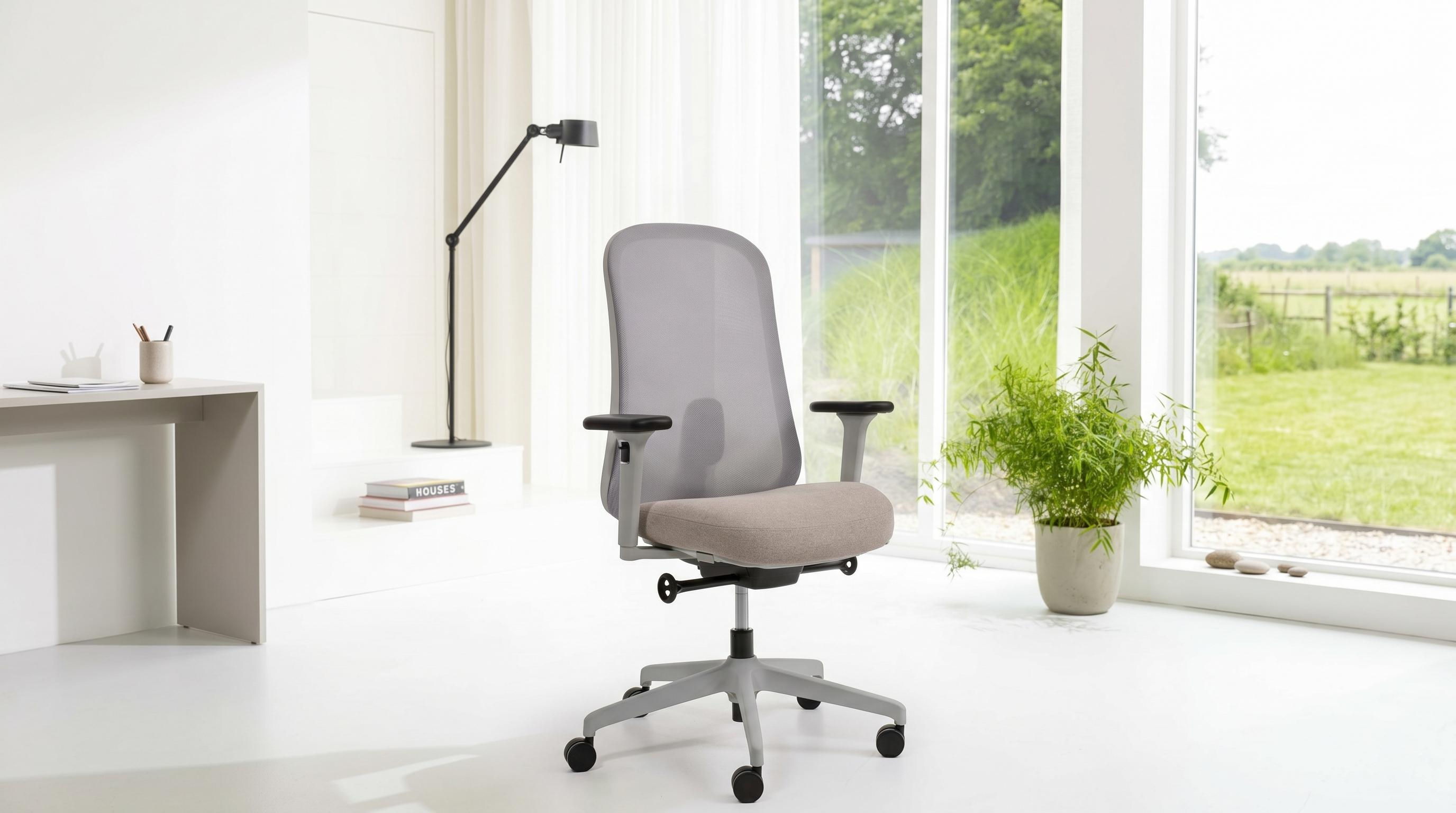 Gray office chair in a bright room with large windows and a desk.